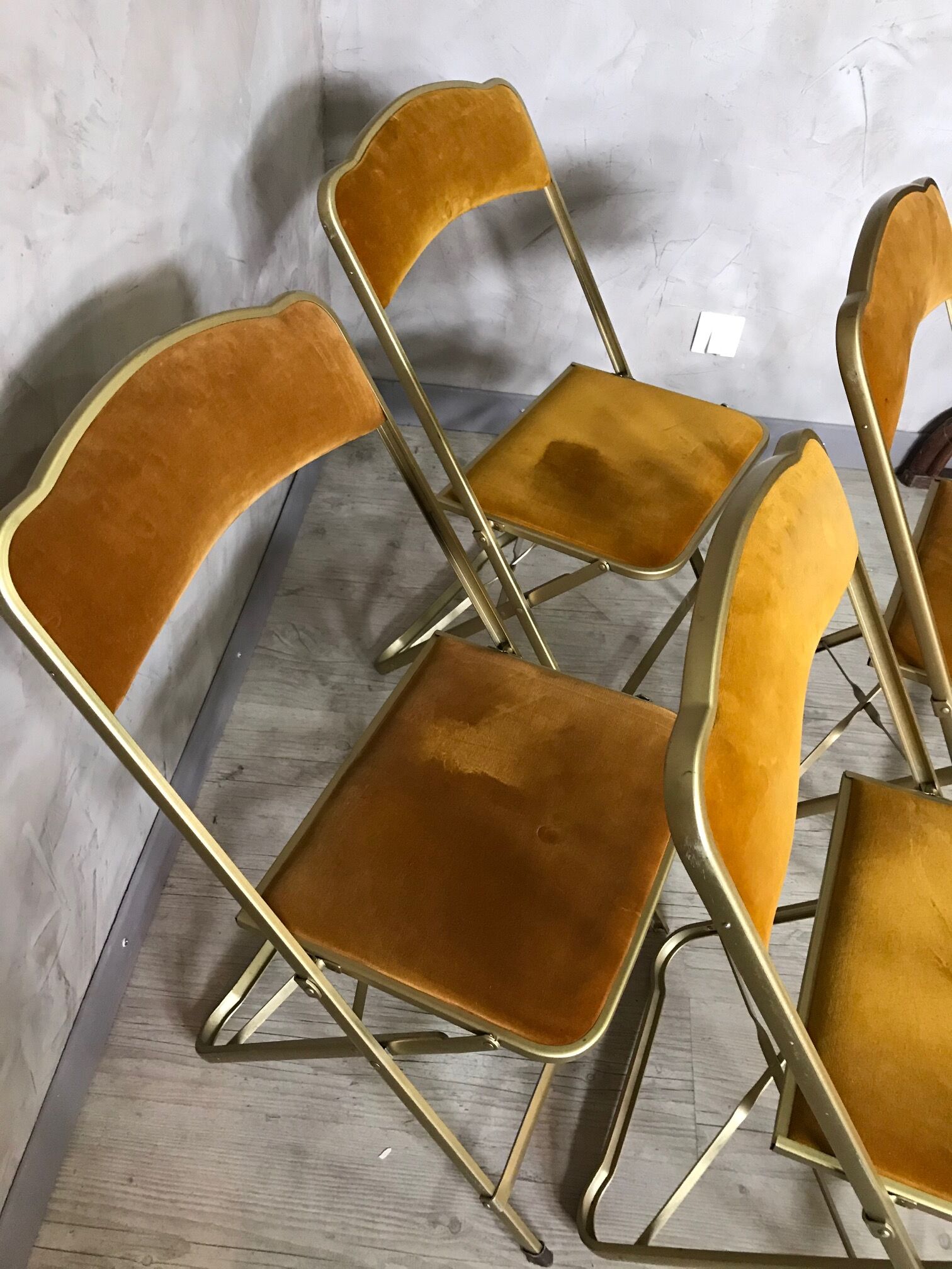 Four folding velvet and brass chairs