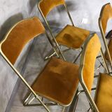 Four folding velvet and brass chairs