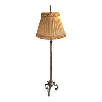 Art Deco floor lamp in bronze metal with a straw yellow fabric shade, twisted shaft, and tripod base.