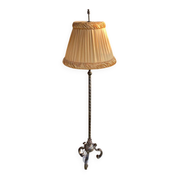 Art Deco floor lamp in bronze metal with a straw yellow fabric shade, twisted shaft, and tripod base.