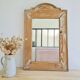 Antique mirror in raw wood with a patina and pediment.