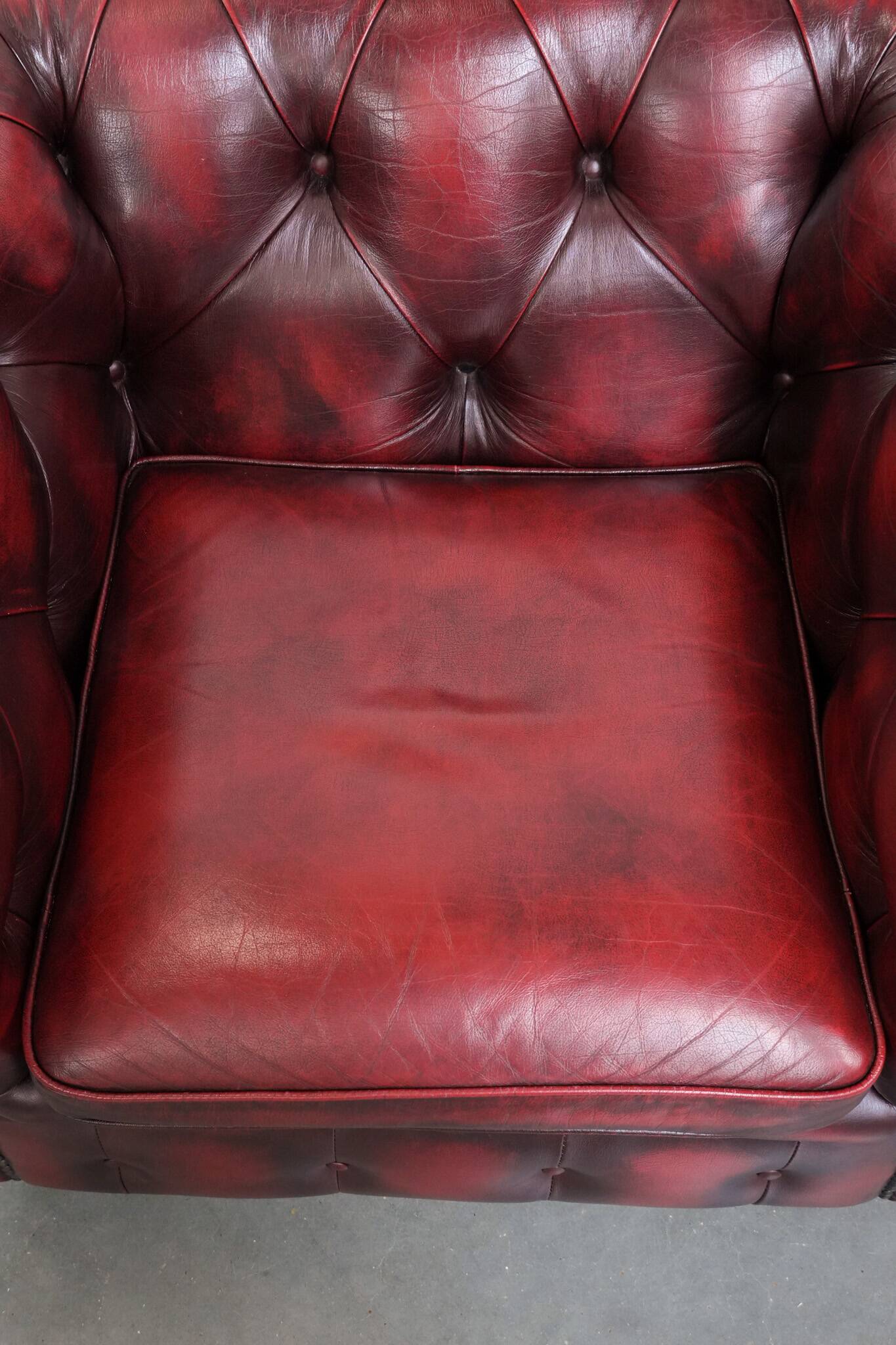Red English cowhide Chesterfield armchair finished with decorative nails