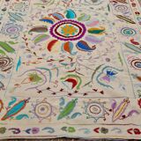 White suzani kilim rug with embroidered multi-colored patterns
