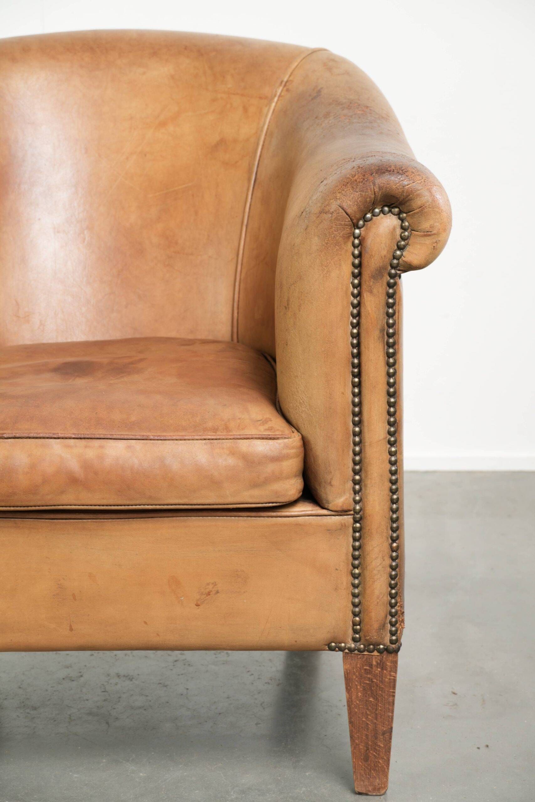 Fauteuil club en peau de mouton confortable de couleur cognac.