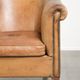 Fauteuil club en peau de mouton confortable de couleur cognac.