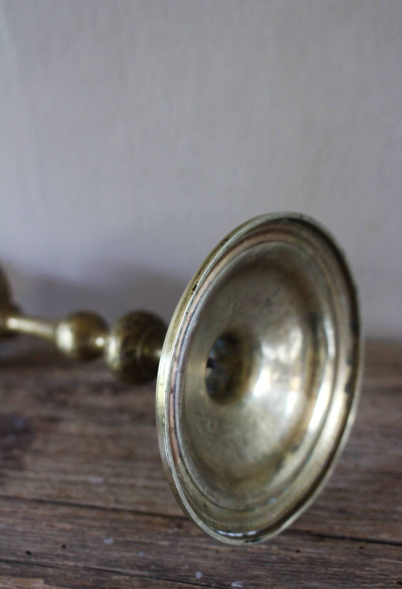 Brass candle holder with flowers and round shape.