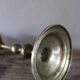 Brass candle holder with flowers and round shape.