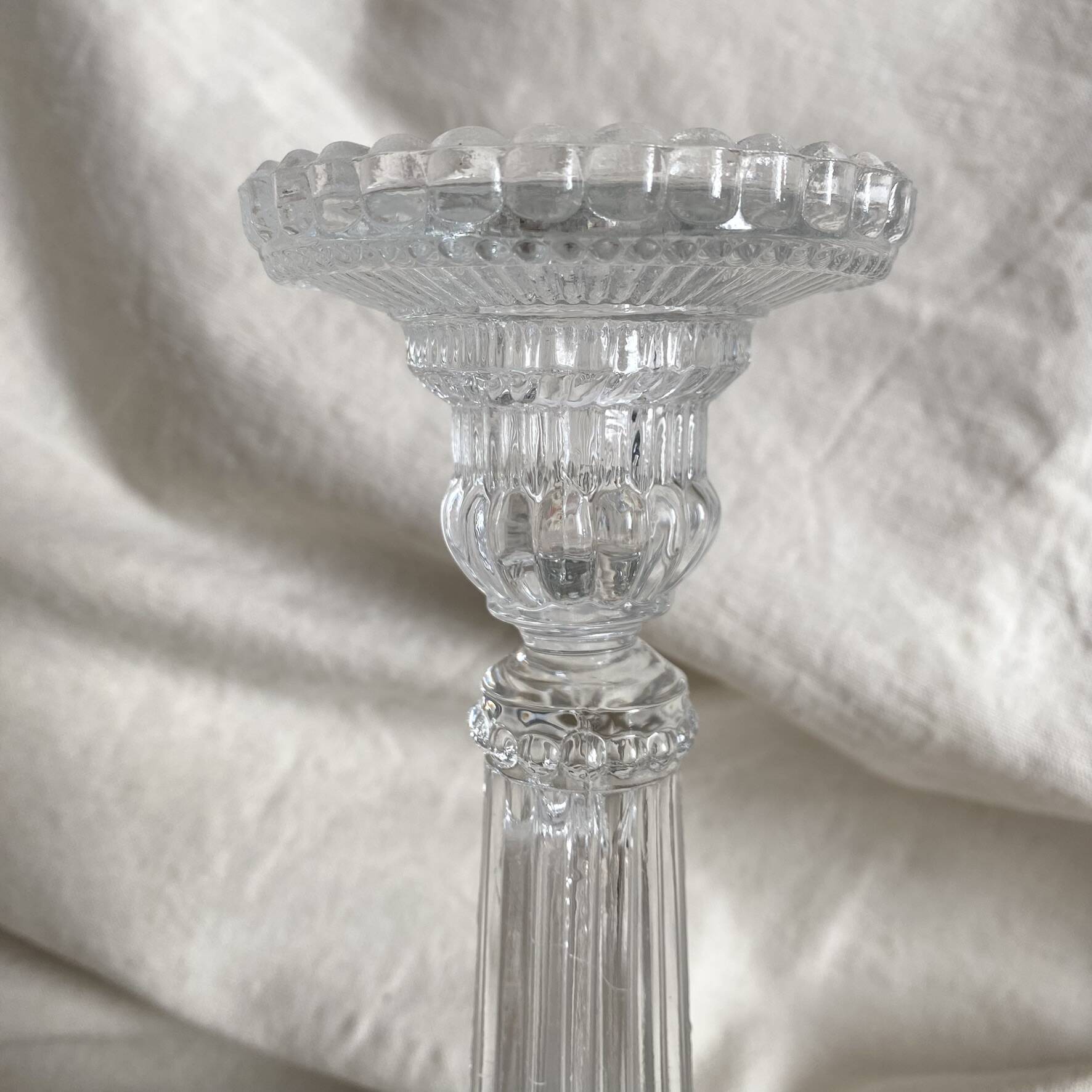 Column candle holders in moulded glass made in France.