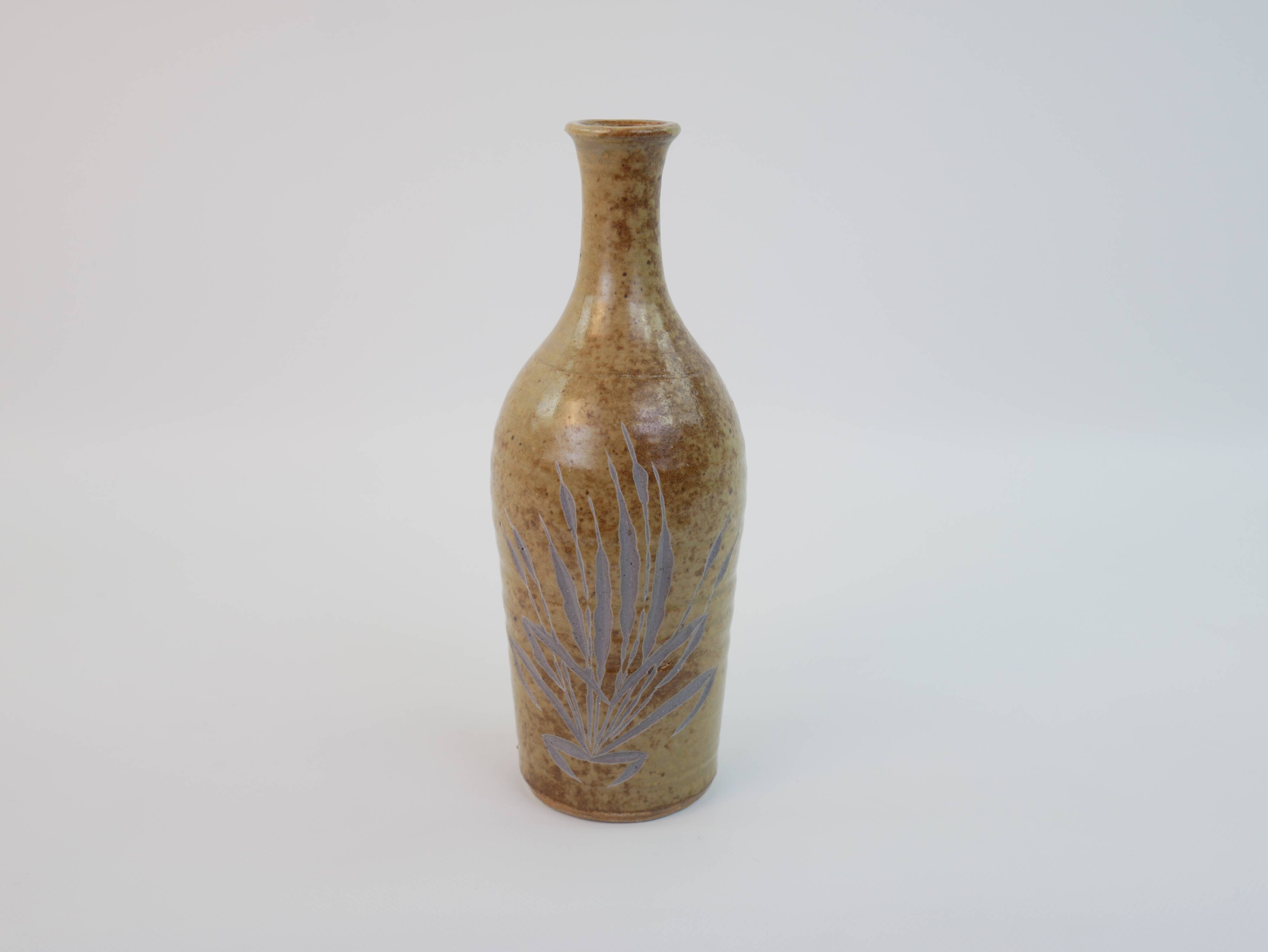 Brown ceramic/stoneware bottle with chiseled floral pattern