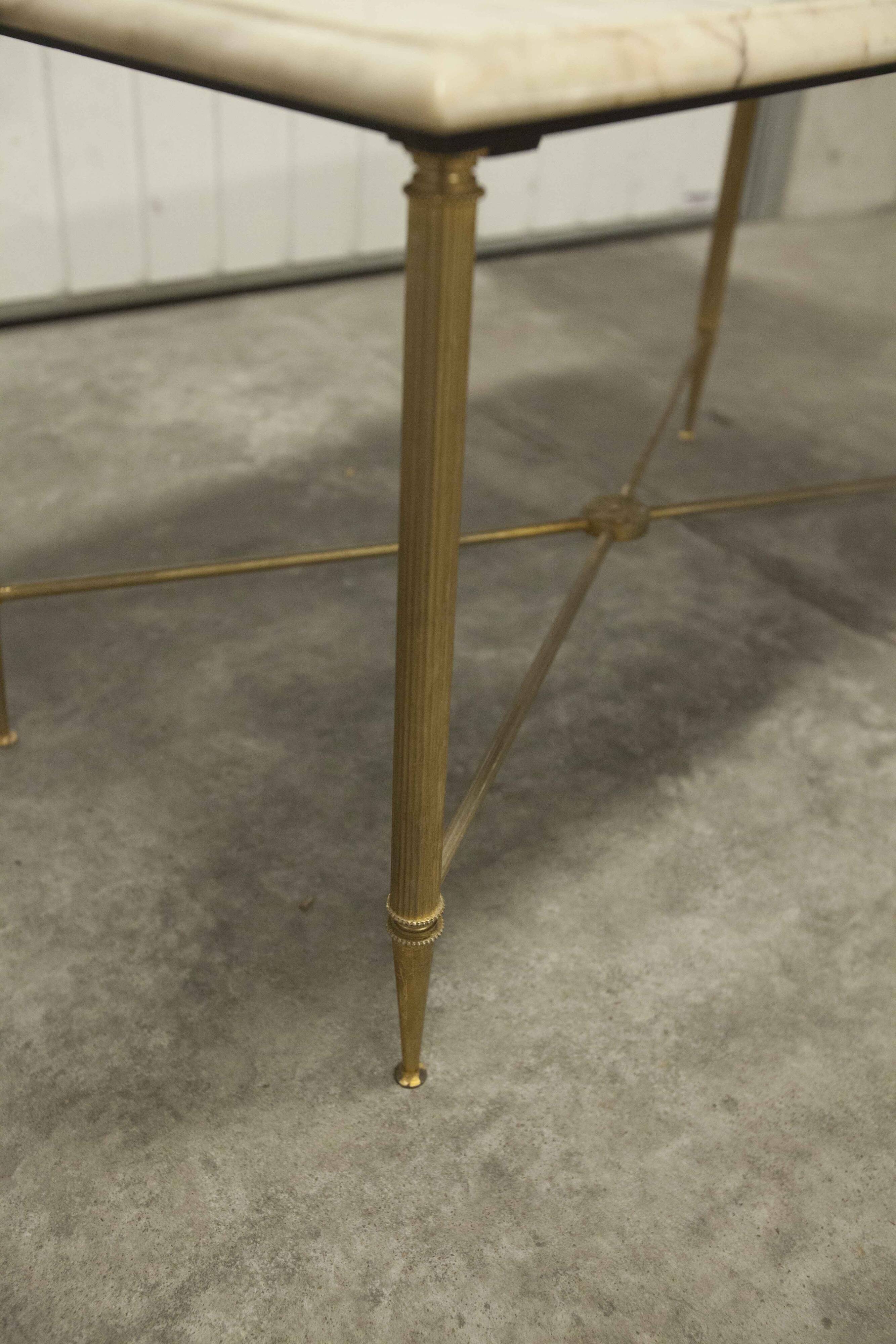 Marble coffee table with brass legs, height 46 cm.