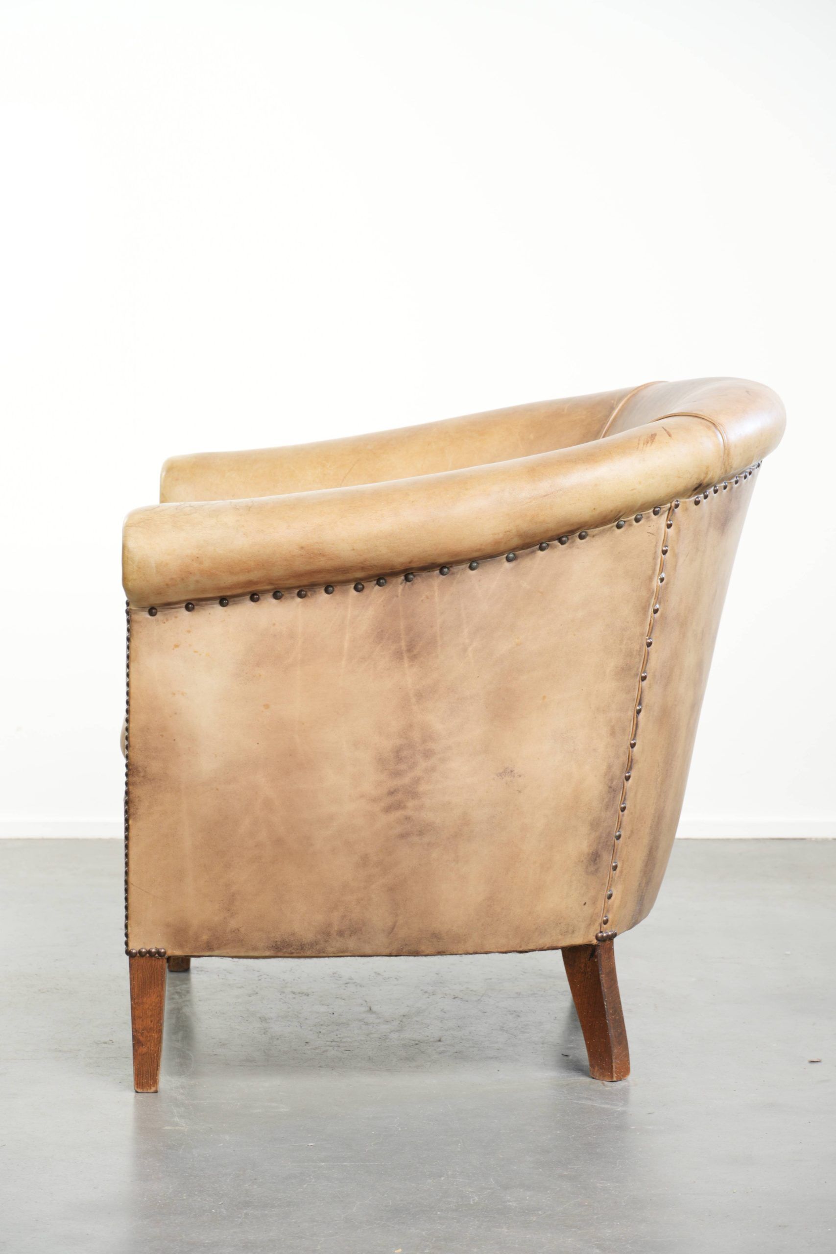 Vintage cowhide club armchair in English style in a light colour scheme