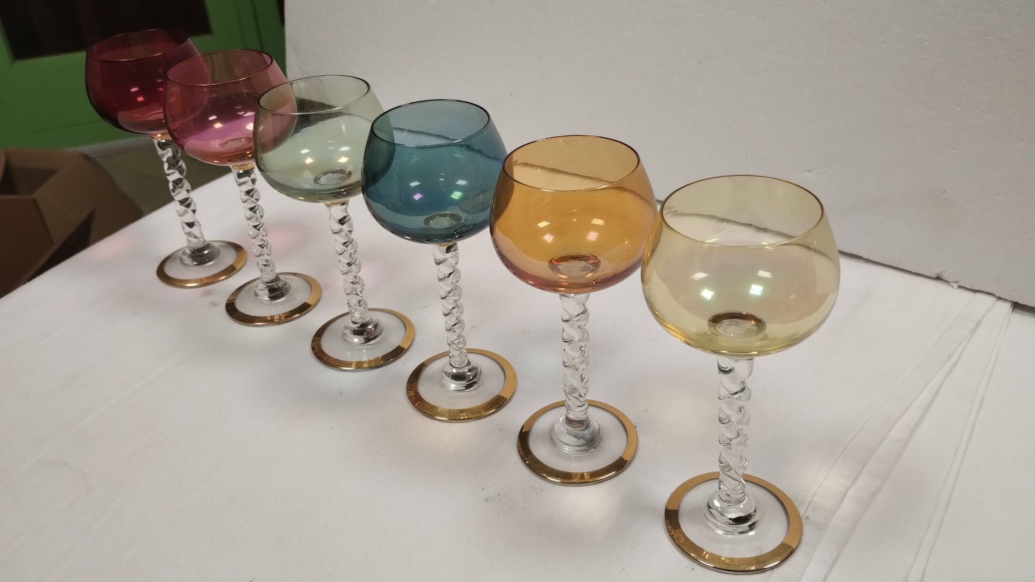 Set of 6 colored crystal stemmed glasses with gold twisted foot.