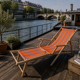 Vintage deck chair with orange and grey striped fabric, original patina.