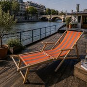 Vintage deck chair with orange and grey striped fabric, original patina.
