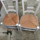 Pair of straw-seated chairs with white-stained wood.