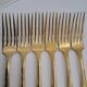 12 Table Forks in gold metal