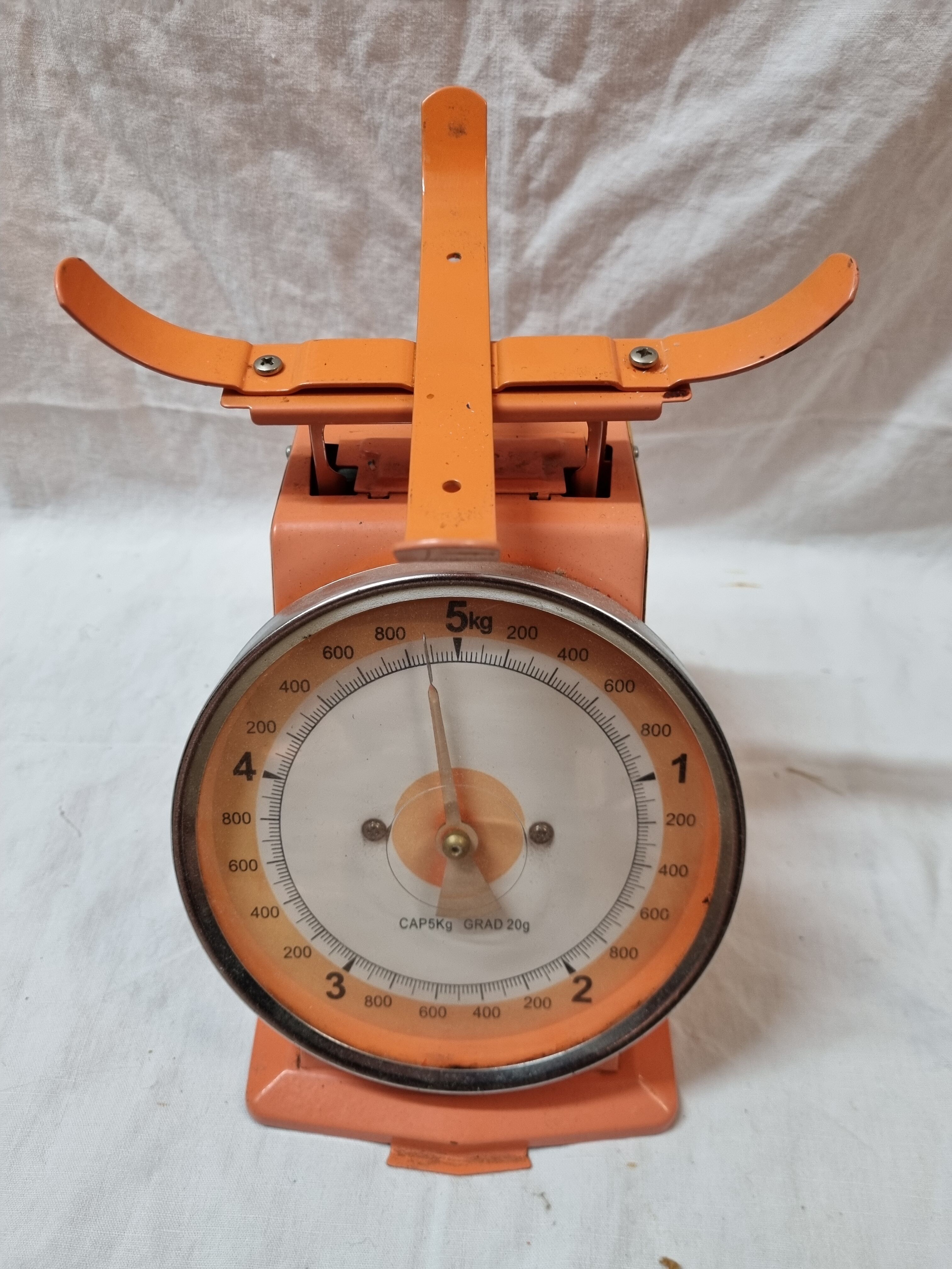 Orange metal household scale from 1970