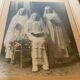 Large frame old photograph of a trio of communicants.