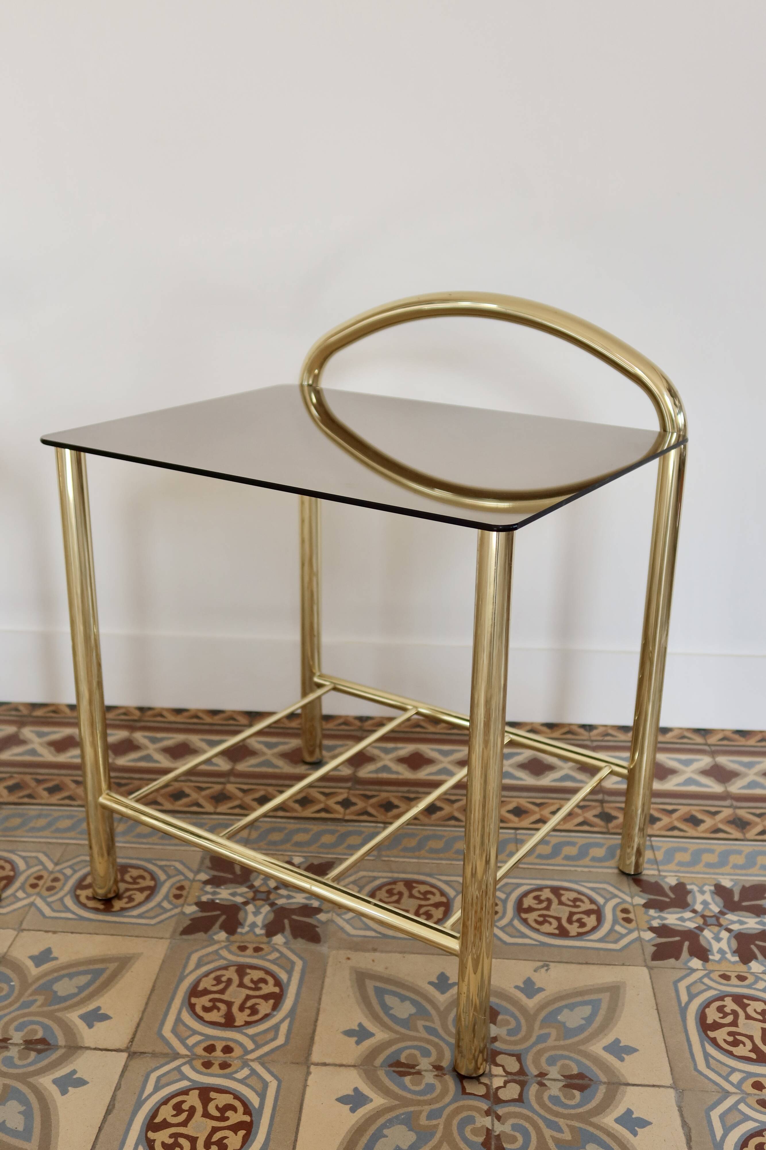 Pair of bedside tables with gold metal and mirrored glass top.