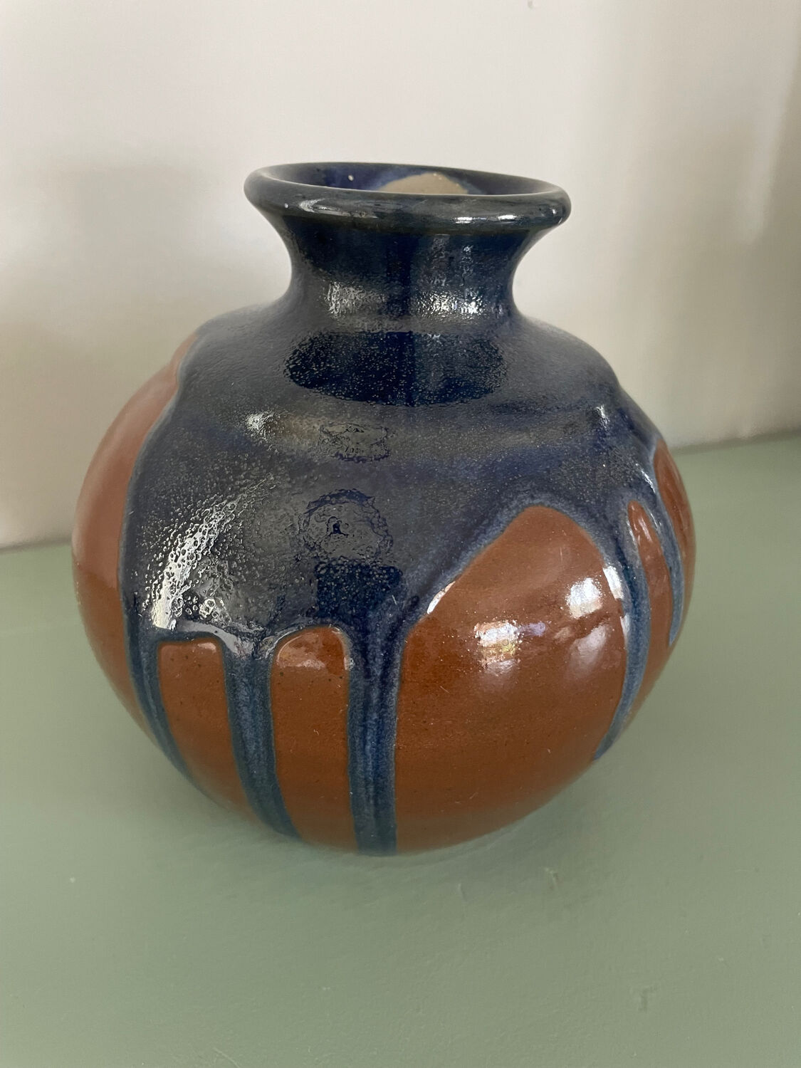 Old blue and brown vase with drips.