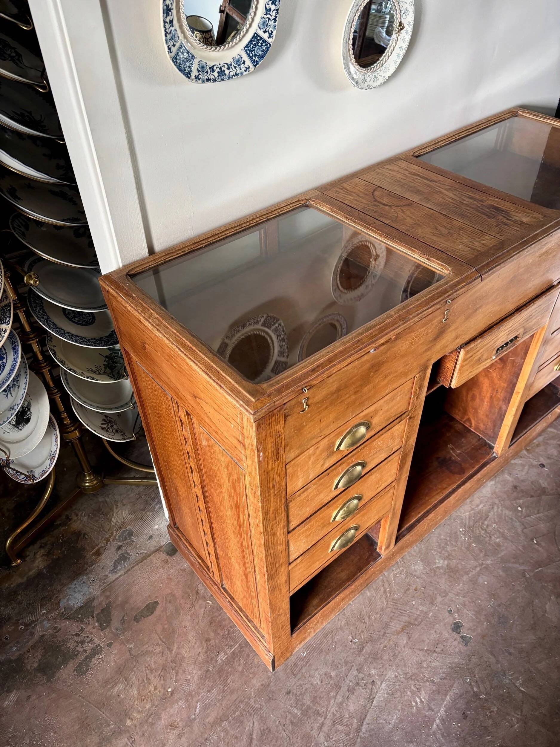 Counter, glass-fronted wooden workbench in dark wood, 8 drawers.