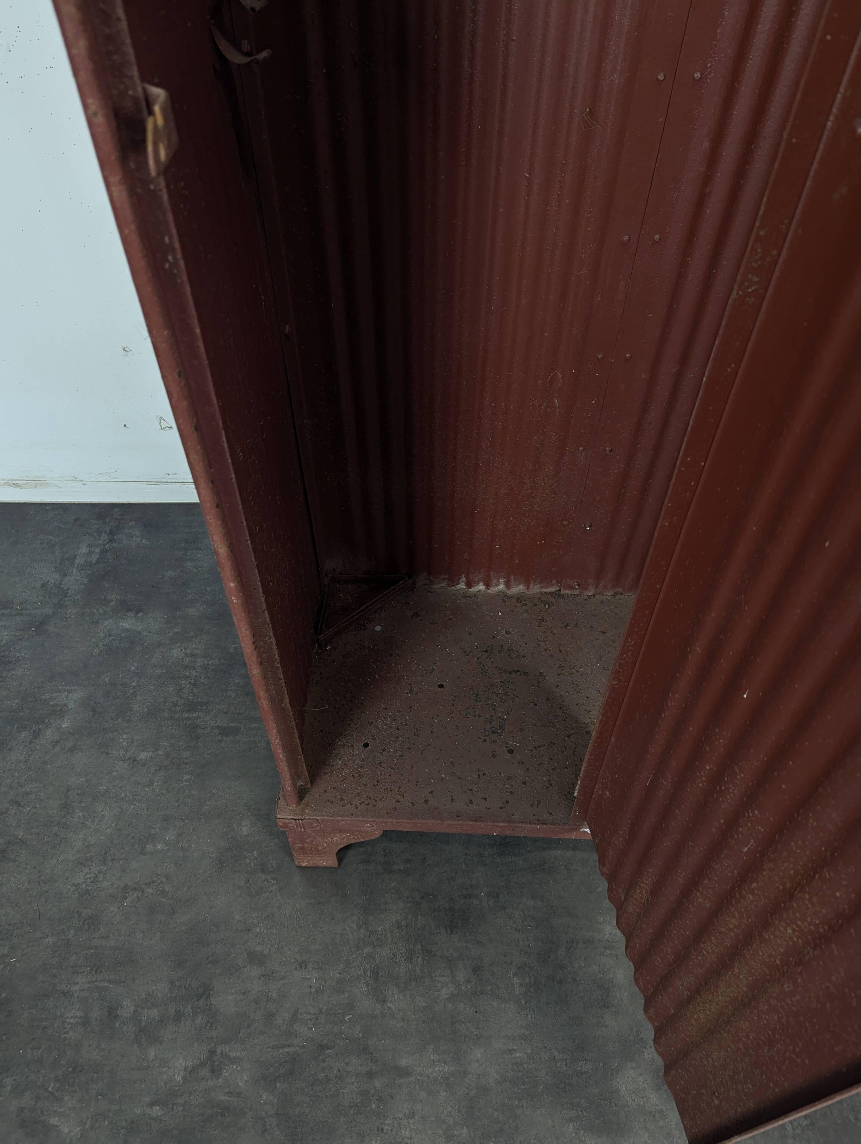 Red painted metal workshop locker with two doors.
