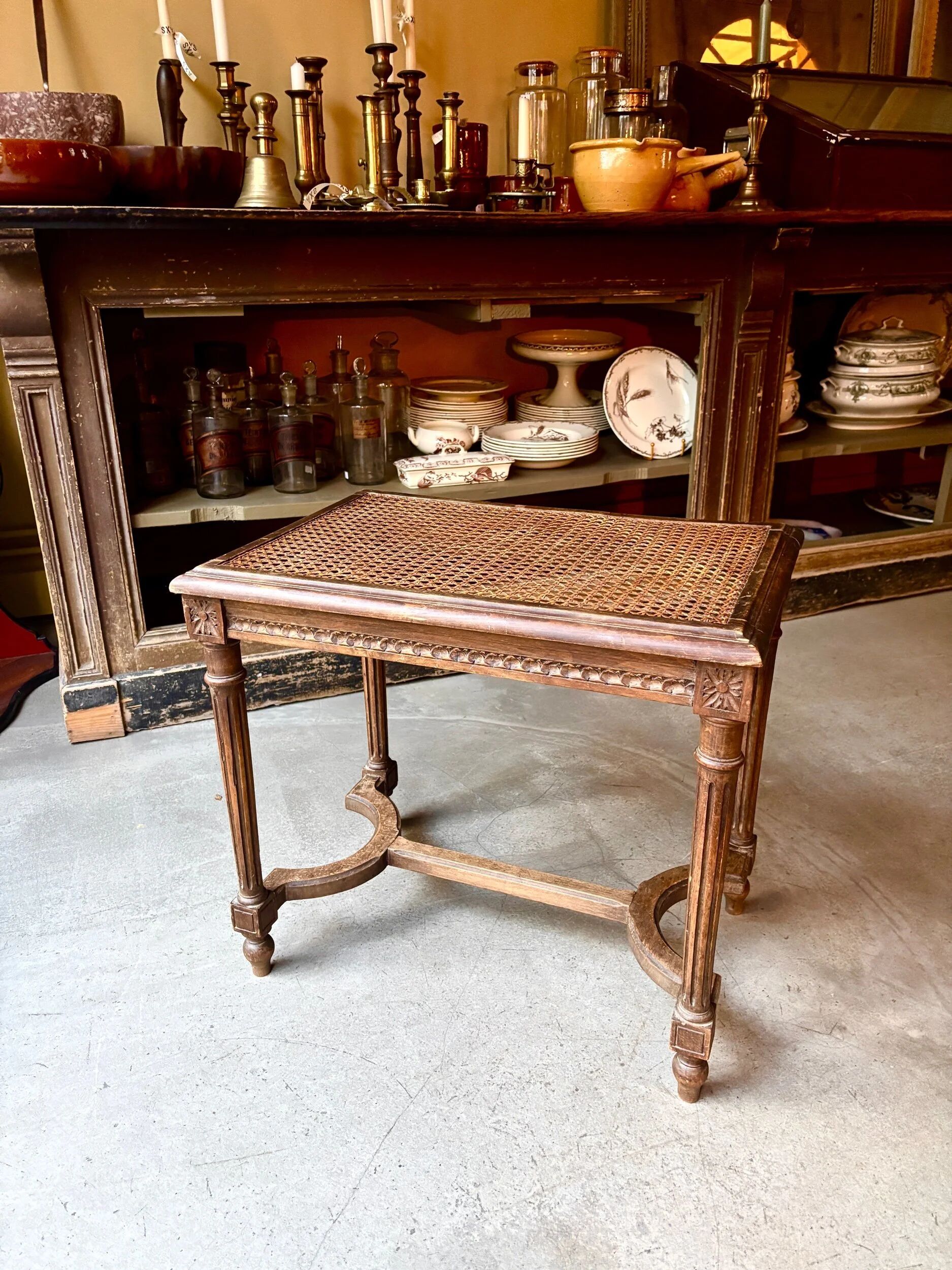 Stool, small wooden piano bench with carved details and caning.