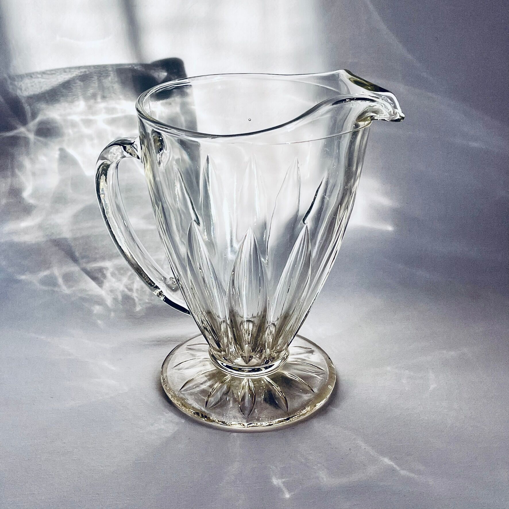 Glass pitcher on base