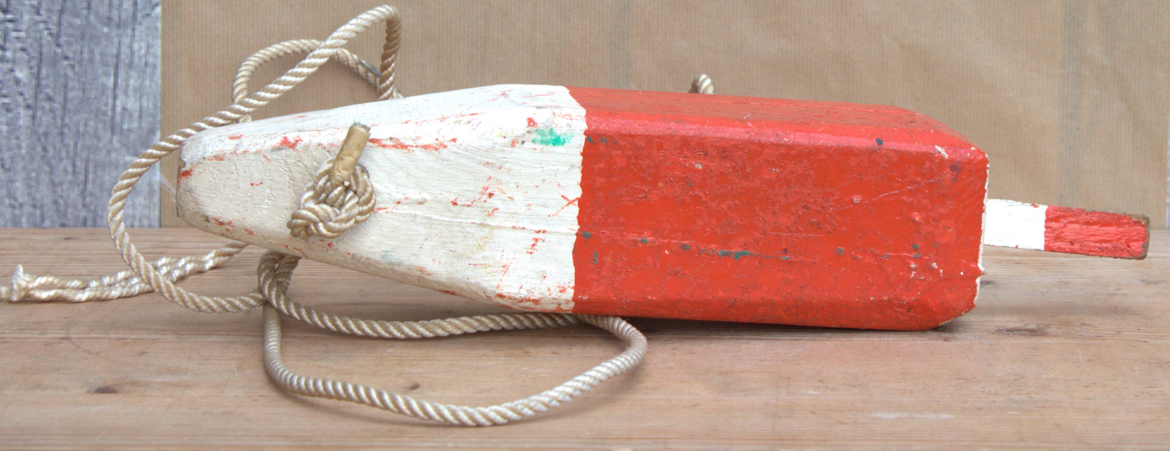 Old red and white wooden buoy