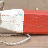 Old red and white wooden buoy