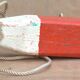 Old red and white wooden buoy