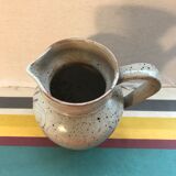 Old gray pitcher with black drawings and vintage stamped handle