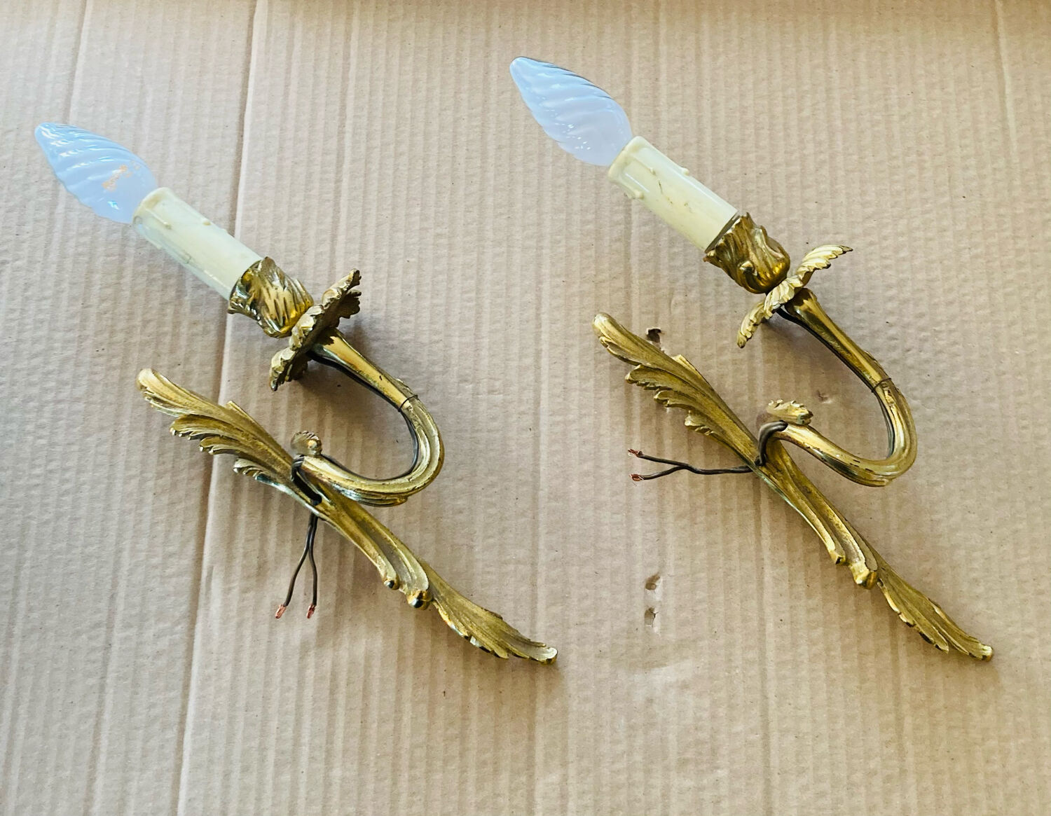 Bronze wall lights in the Louis XV style with curved branches and leaf decorations.