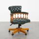 Classic green leather Chesterfield office chair on wheels.