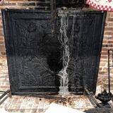 huge old fireplace plate has decoration of angels, crown and fleurs-de-lis