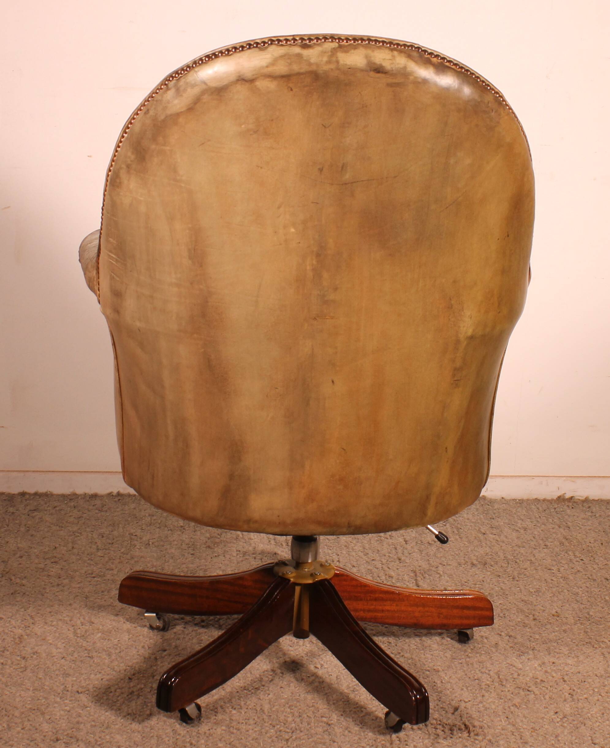 Office chair known as a presidential chair in mahogany and cognac leather.