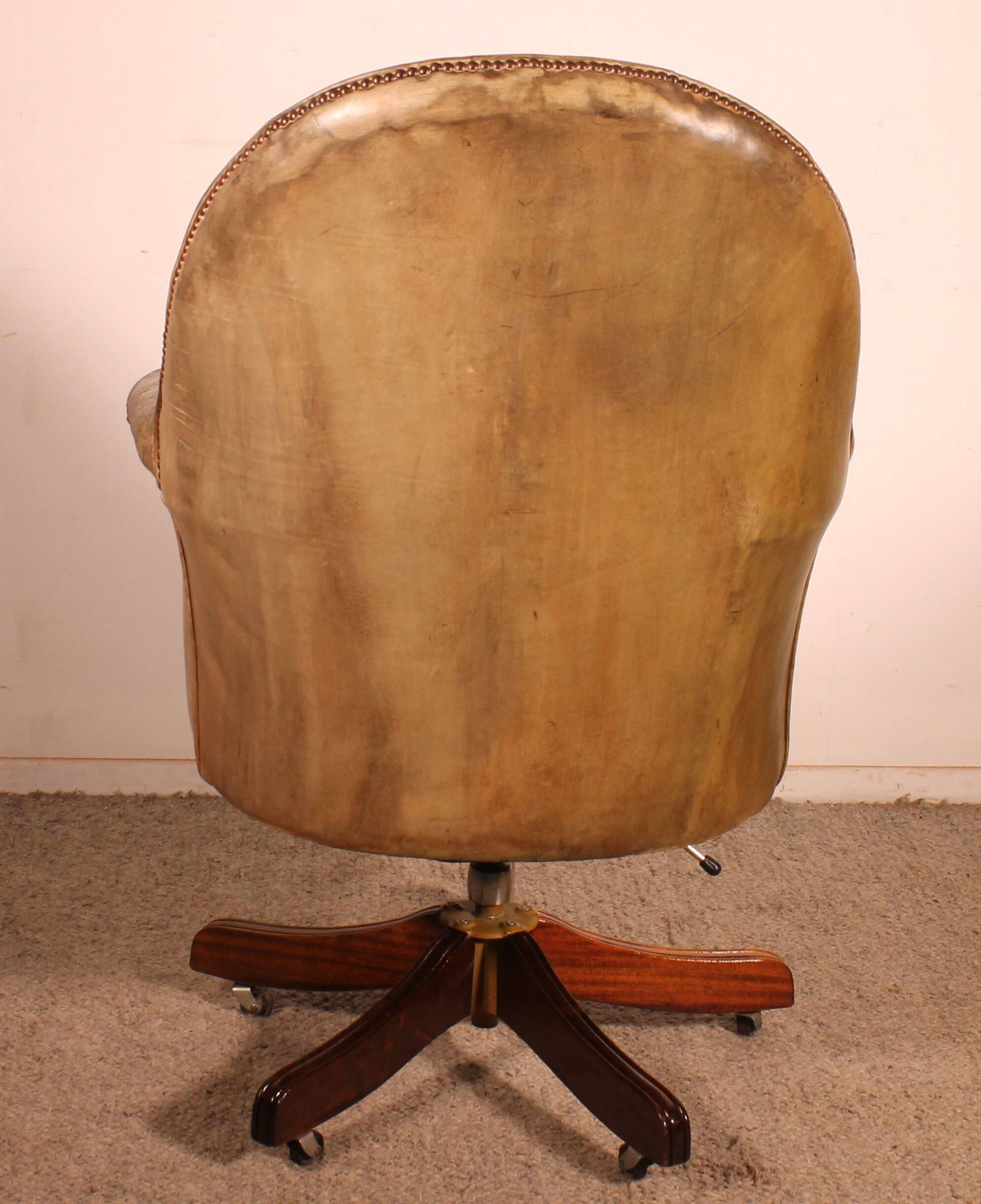 Office chair known as a presidential chair in mahogany and cognac leather.