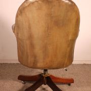 Office chair known as a presidential chair in mahogany and cognac leather.