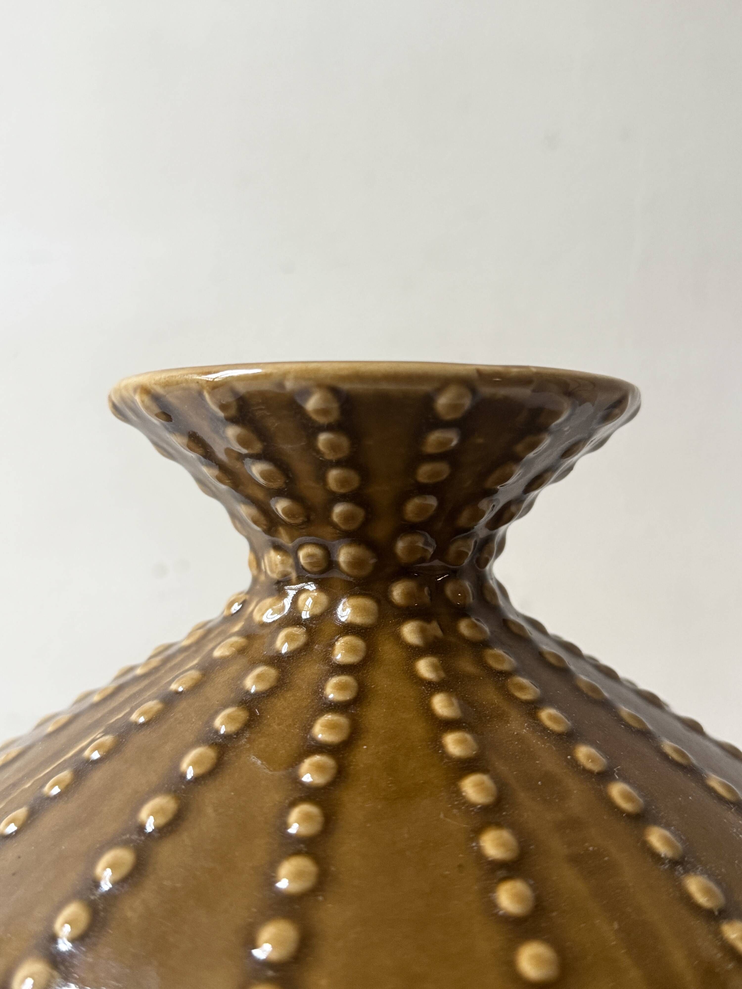 Pyriform vase in glazed ochre ceramic and beads.