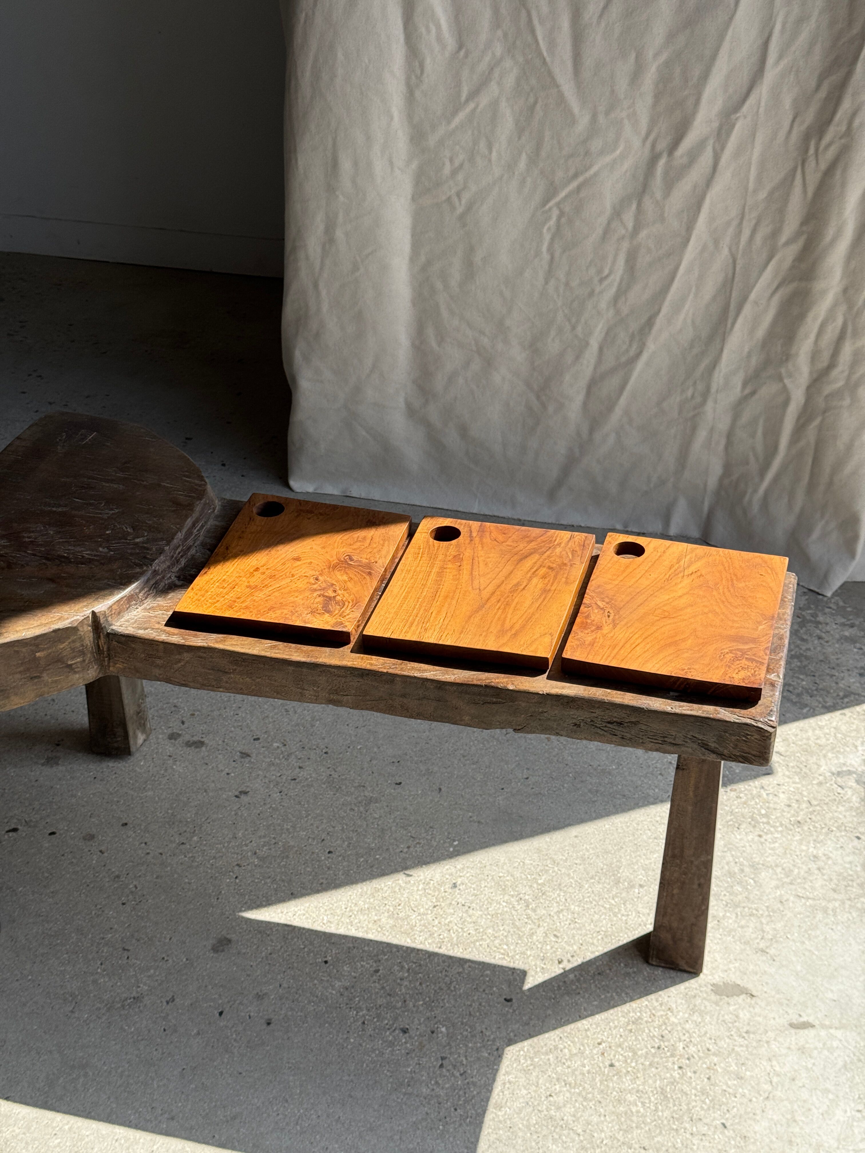Small rectangular teak monoxyle cutting board with a circular handle.