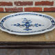 Old large oval ceramic dish with a black bottom.