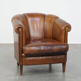 Unique vintage cognac-coloured leather club armchair with black piping