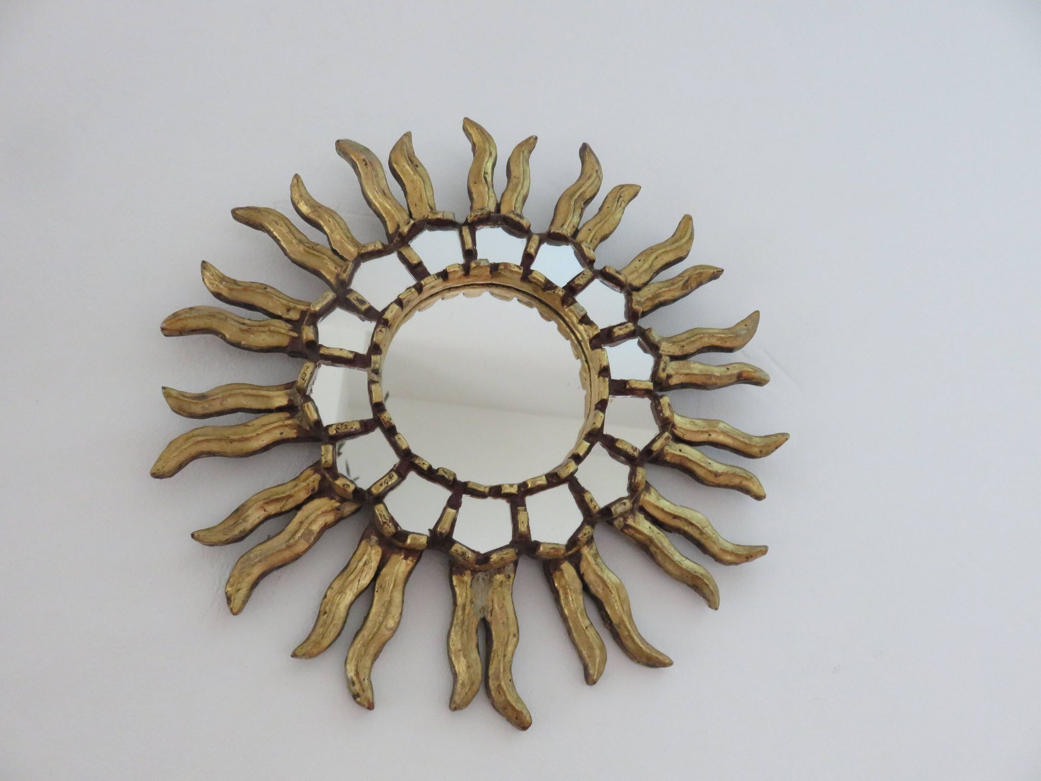 Golden wooden sun mirror with inlays from the early 20th century.