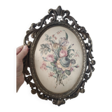 Golden brass frame with bouquet of flowers on silky fabric