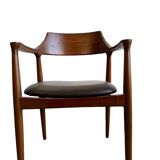 Curved wooden dining chair with brown leather seat