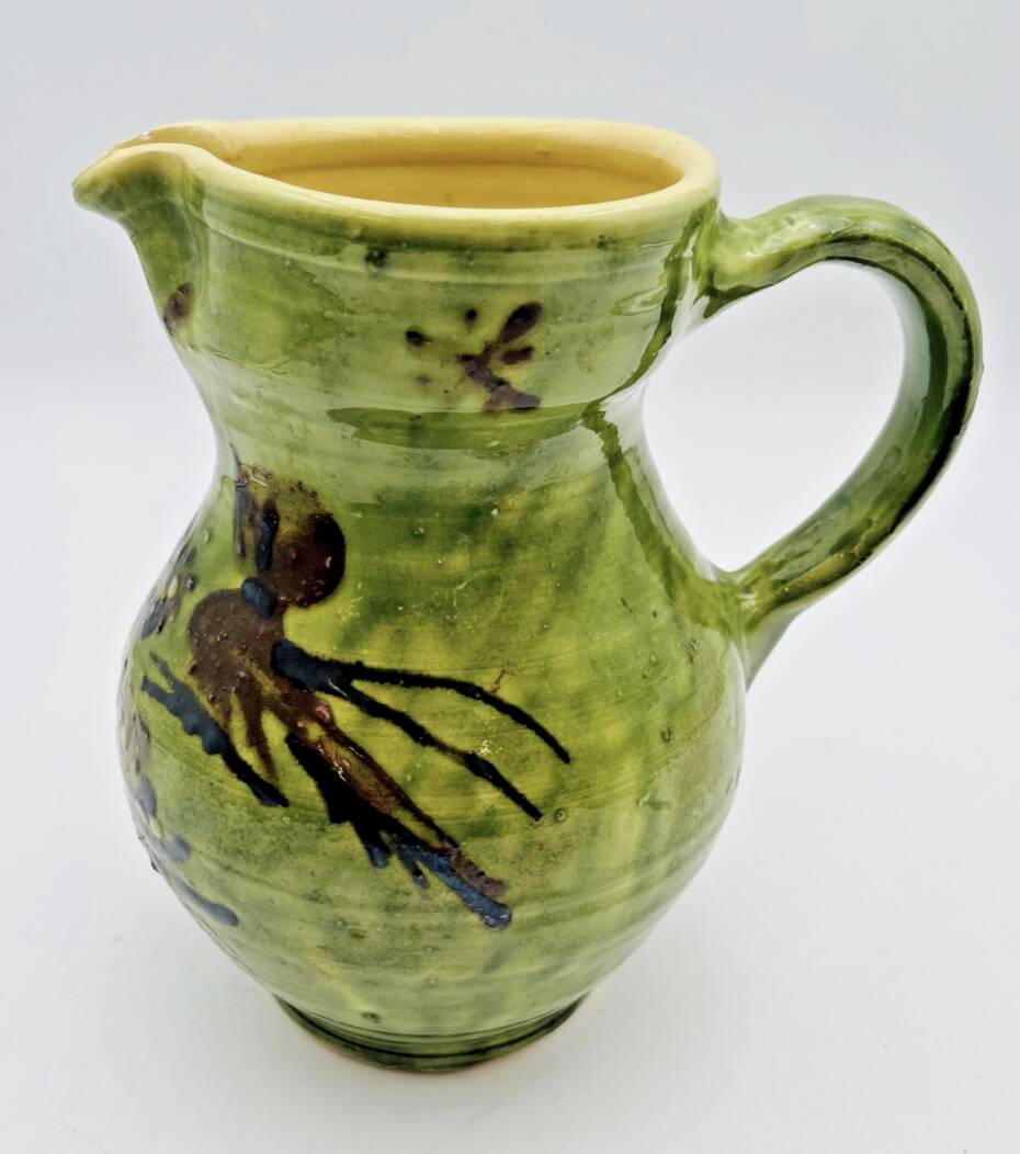 Green stoneware pitcher with flower and brown bird decoration