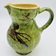 Green stoneware pitcher with flower and brown bird decoration