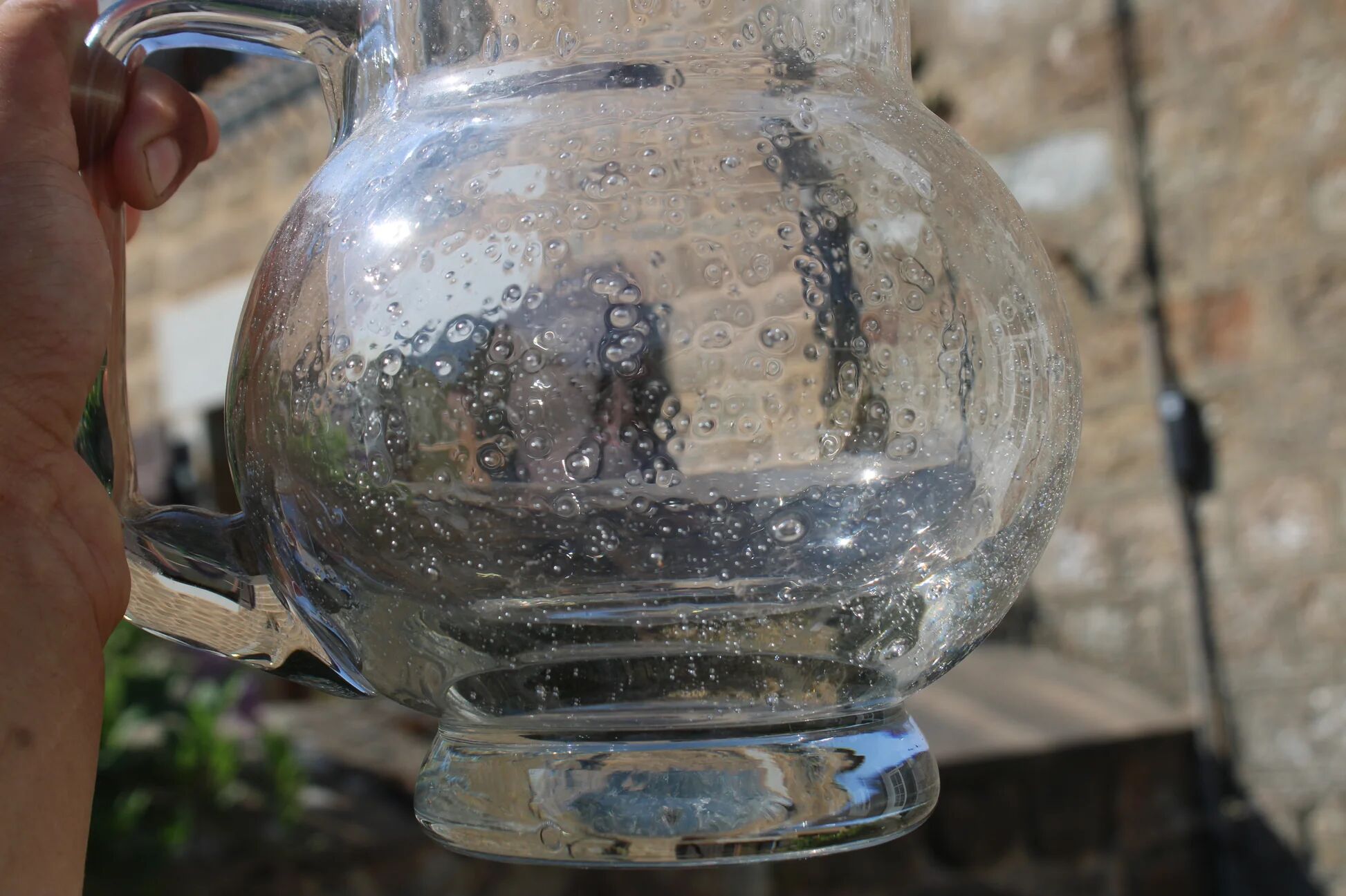 Vintage blown glass pitcher with bubbles, transparent.
