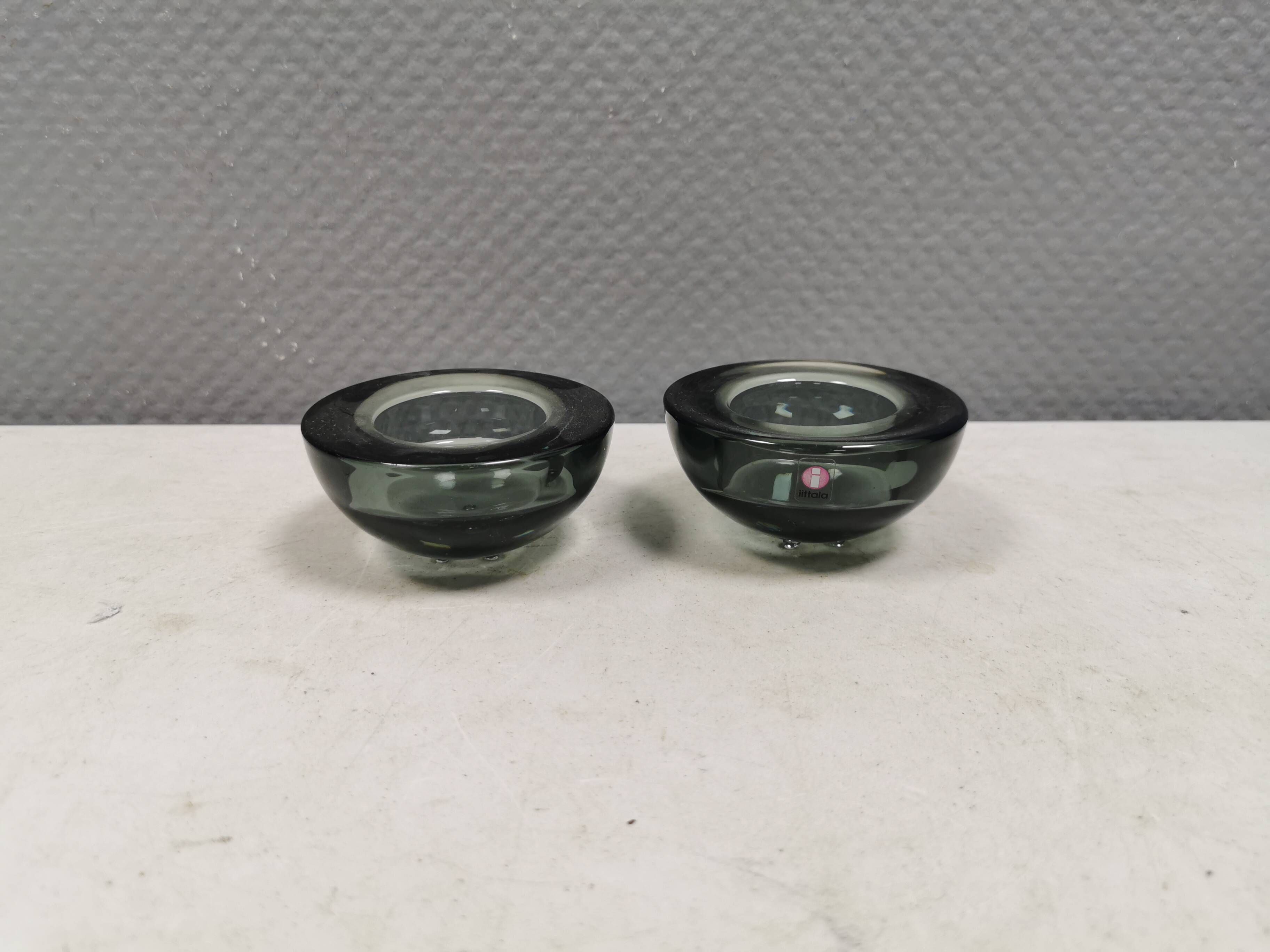 Un ensemble de porte-bougies iittala en verre transparent fumé.
