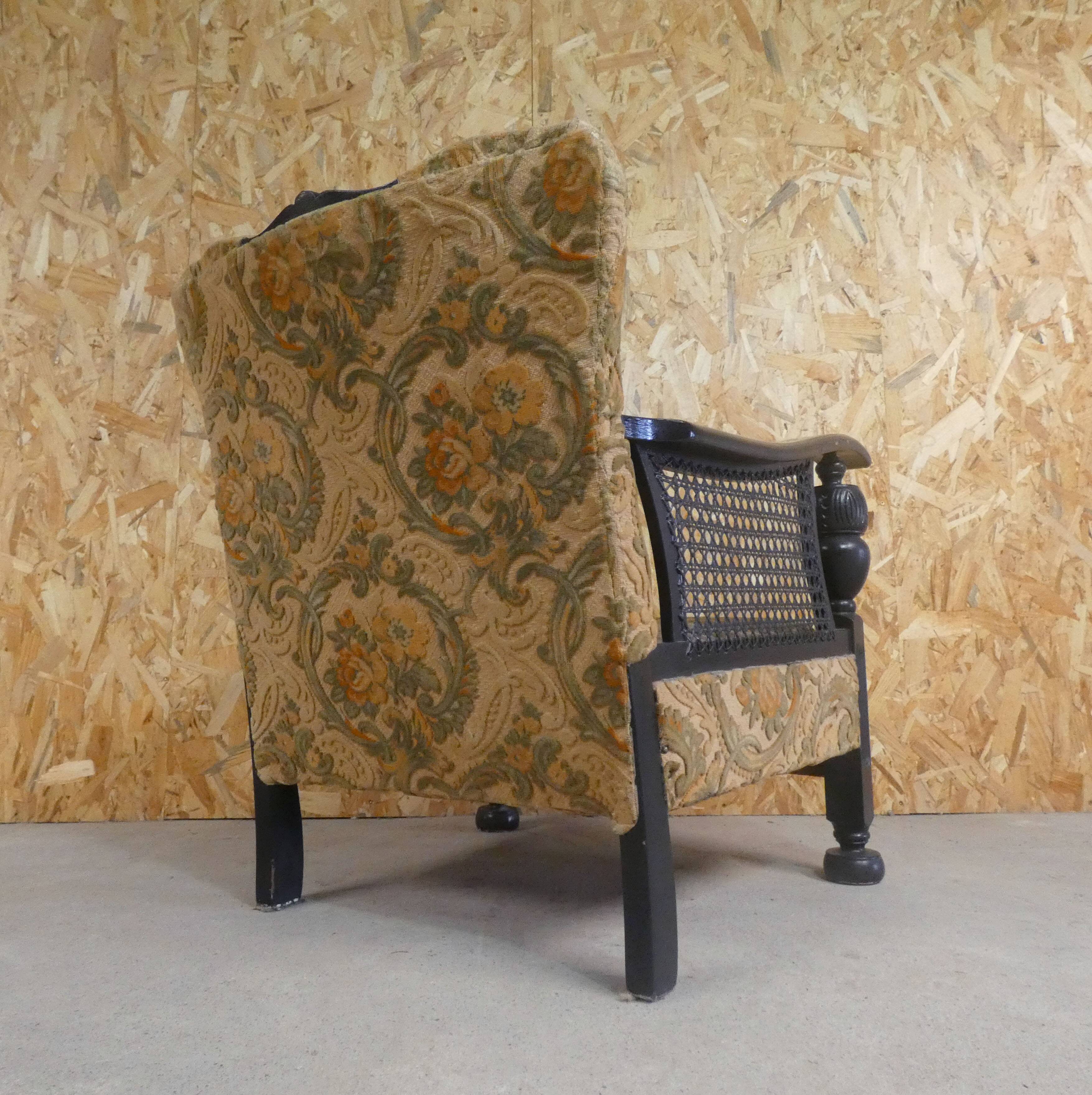 Old armchair upholstered in velvet, carved and caned wood